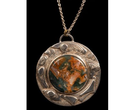 A silver and moss agate pendant by Helen Newman, Birmingham 1974, the circular agate panel in a chased silver mount suspended