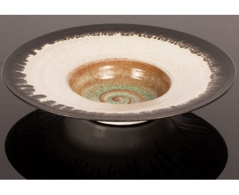Peter Wills (born 1955), large footed porcelain bowl with wide rim, speckled white tin glaze, the interior in ochre and sea g
