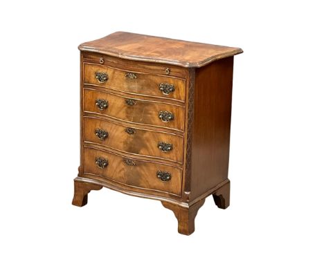An Early 20th Century Chippendale Revival mahogany serpentine front chest of drawers, with brushing slide and closed fret cor