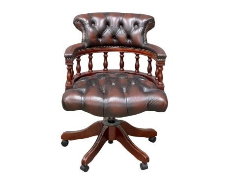 A deep button leather swivel desk chair.