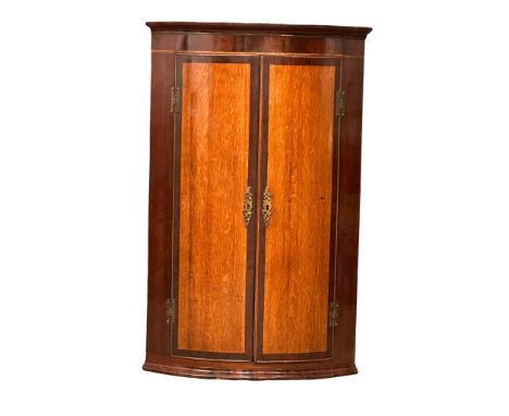 A Late 18th Century George III inlaid mahogany wall hanging corner cupboard, with oak panel doors and fitted shelves. Circa 1