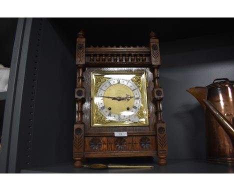 A large extensively carved Victorian oak bracket clock having gilt detailing to face.