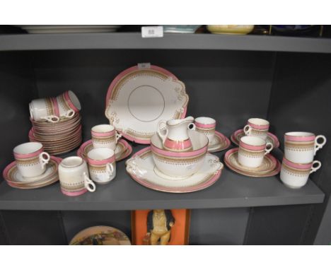 A Victorian tea service including cups and saucers,plates,jug and more with brown transfer motif, pink banding and gilt detai
