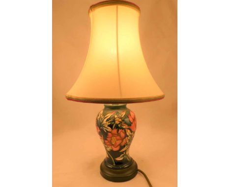 A Moorcroft Pottery green ground lamp base decorated with stylised pink flowers and  foliage, 25.5 cm H, complete with shade.