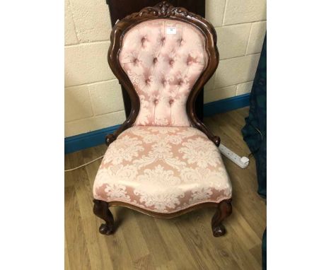 A Victorian mahogany show frame Nursing Chair, carved cresting rail and front cabriole legs, upholstered button back and stuf