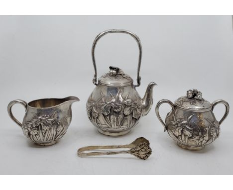 A Japanese three piece silver tea service, Meiji period, of fine quality, comprising swing handled teapot and cover, twin han