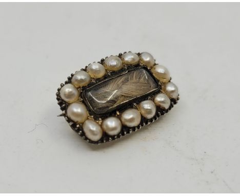 A Georgian white metal and pearl set mourning brooch, with rectangular glazed panel over braided hair. length 20mm. (gross we