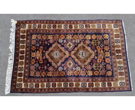 A 20th century Afghan Ardebil carpet rug having two central diamond motifs surrounded by geometric patterns within the centra