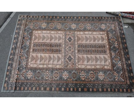 A large vintage 20th century Persian Islamic rug carpet having panels of geometrically patterned motifs in a brown and beige 