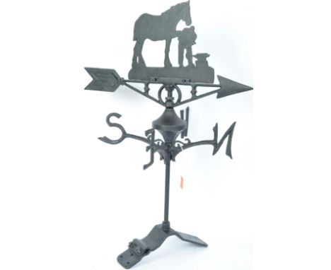 A vintage style cast iron polychrome weather vane having horse and blacksmith to the directional arrow with gilt points of th