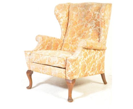 A mid century Parker Knoll type wingback armchair with footrest mechanism extension. Raised on cabriole legs with pad feet ha