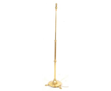 An early 20th century Arts &amp; Crafts brass standard floor standing lamp having extending tubular shaft with hammered circu