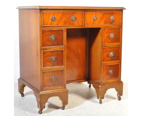 A Regency revival mahogany and leather kneehole twin pedestal desk. Raised on bracket feet with a series of drawers beneath l