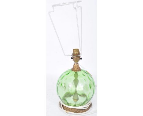 A retro vintage mid 20th century glass carboy type table lamp having an indented green glass of globular form raised upon a g