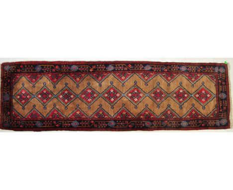 A 20th century Persian Islamic Hamadan rug / carpet having a row of central red medallions and floral detailing to the outer 