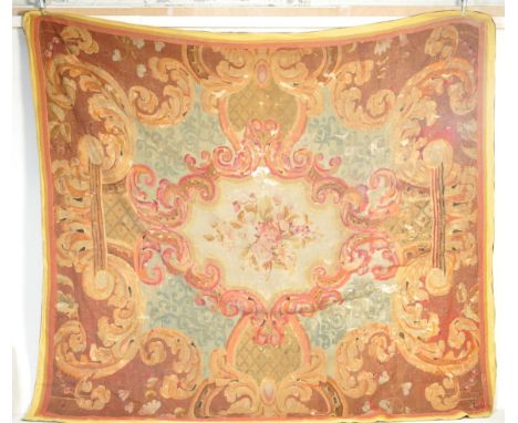 A very large 18th century French Huguenot tapestry wall hanging having a polychrome central floral motif set within a scrolli