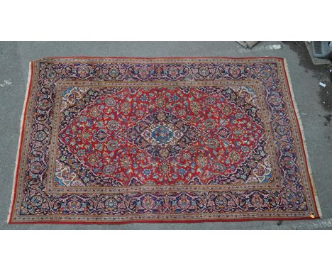 A 20th century Persian Islamic Keshan wool carpet rug having a central medallion surrounded by floral motifs within the centr