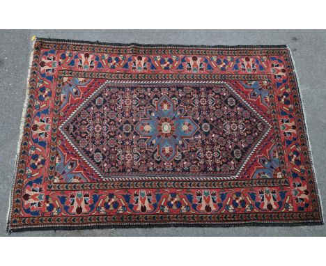 A 20th century Persian Islamic Hamadan rug carpet having a central blue star motif set within a finely detailed lozenge &amp;