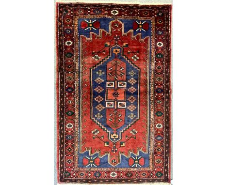 A vintage 20th century Persian Islamic Hamadan rug carpet having a central medallion with geometric patterns, The outer borde