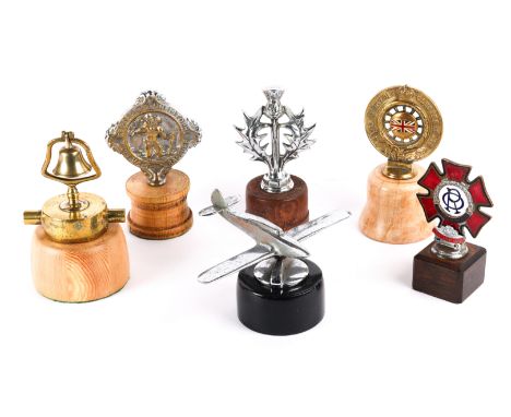 6 car mascots, bonnet ornaments. includes a chromed aeroplane, a thistle, a brass bell, Knight Grand Cross, in brass with red