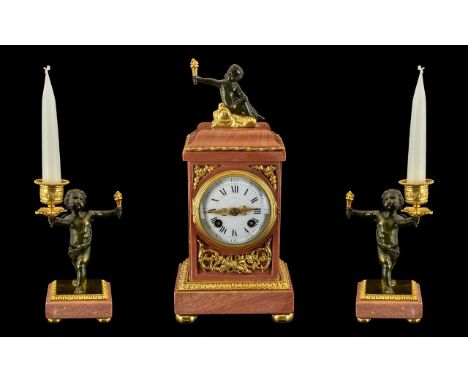 French Clock Garniture.  A pink marble and ormolu mounted clock garniture.  The case of rectangular form, surmounted by a sea