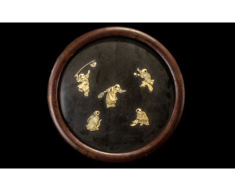 A Japanese Round Lacquered Wall Plaque with applied carved figures in bone of boys playing various pursuits, black panelled i