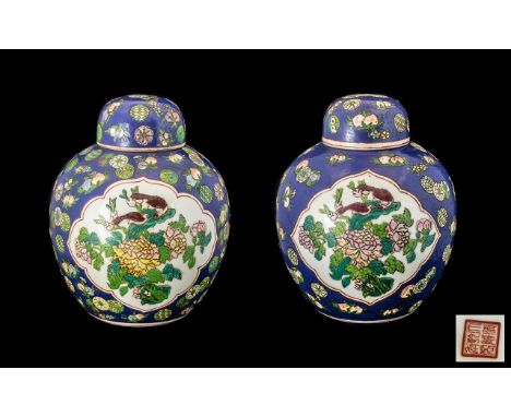 Pair of Blue Ground Famille Rose Lidded Chinese Ginger Jars, the central panels decorated with birds amongst roses; red seal 