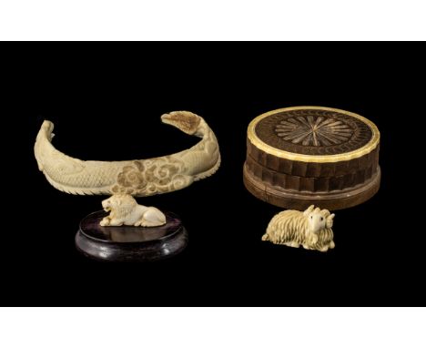 Antique Chinese Carved Boar's Tusk Necklace in the shape of a coiling dragon, a carved ivory netsuke of a ram with horn eyes,