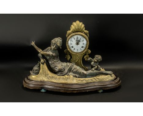 A Reproduction Cast Brass Mantle Clock with a white enamel dial, on a  raised tree decoration beneath a classical maiden with