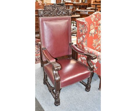 WWII Interest: A heavily carved boardroom armchair with studded leather upholstery, the deep cresting rail carved with a styl