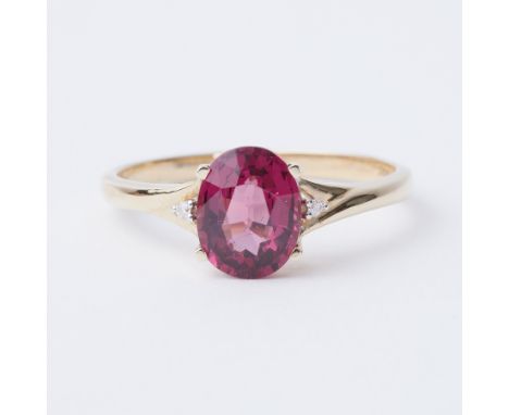 A 9ct yellow gold ring set with a 2.45 carat Comeria Garnet (pink purple hues) set to each side within a small round brillian