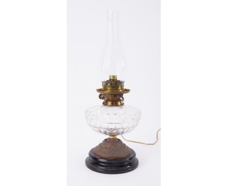 A squat Victorian oil lamp with clear glass reservoir and no shade.