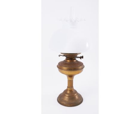 A small brass oil lamp with white shade.