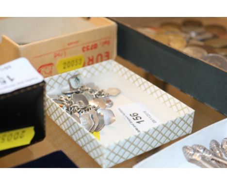 A silver charm bracelet hung with various enamel decorated charms 