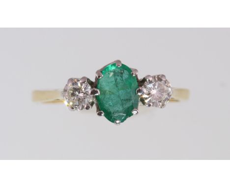 An 18ct H/M emerald and diamond three stone ring, approx total diamond weight 0.40ct, approx 2.3gms, size M