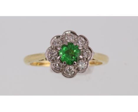 An 18ct diamond and green stone cluster ring, approx total diamond weight 0.60ct, approx 4gms, size M