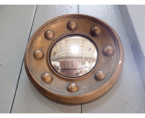 A SMALL REGENCY STYLE CONVEX MIRROR in a cast plaster frame 25 cm diam (chips)