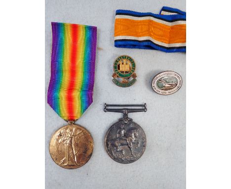A FIRST WORLD WAR MEDAL PAIR engraved, '201814 PTE. W. WELLSTEAD. DORSET. R.' a Dorset Rgt badge and a similar badge