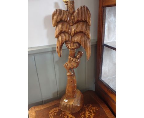 A WOOD AND BRASS LAMP in the form of a man climbing a palm tree 60 cm high, plus fitting