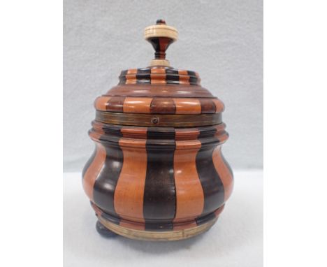 A DUTCH TREEN MULTI-COLOURED  TURNED CADDY or tobacco jar, of squat baluster form, brass-bound, with bone-mounted finial 20 c