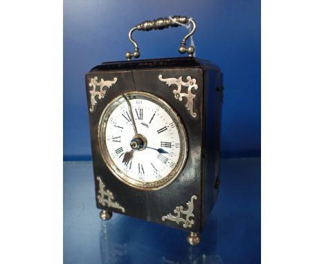 A FRENCH ALARM TABLE CLOCK in an ebonised case with white enamel face, 16cm high (inc handle)