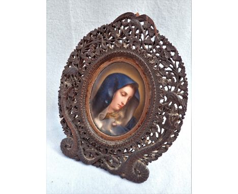 A 19TH CENTURY OVAL CERAMIC PORTRAIT OF A WOMAN in a carved oval easel frame, 24cm high (overall)