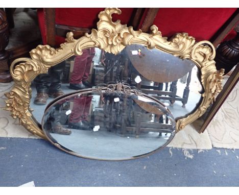 A GILT FRAMED ROCOCO WALL MIRROR and an oval wall mirror (2)