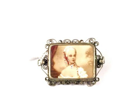 A miniature portrait brooch in filigree white metal frame