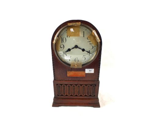 A dome topped Oak striking mantel clock (loose glass)