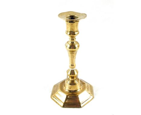An early 18th Century seamed Brass candlestick with wax ejector aperture, knopped stem and octagonal base, height 8"