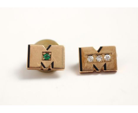 A pair of of untested emerald set yellow gold gentlemen's dress studs, the 'M' shaped studs with black enamel detail and gree