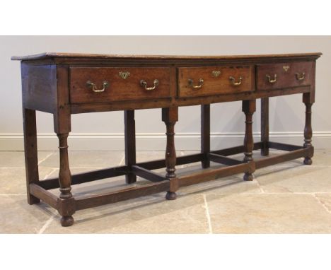 A George III oak dresser, the associated open plate rack formed with three shelves and a pair of spice cupboards, upon the ba
