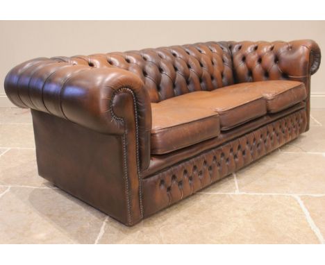 A chestnut brown leather Chesterfield type button-back three seater sofa, late 20th century, of typical deep set form, with t