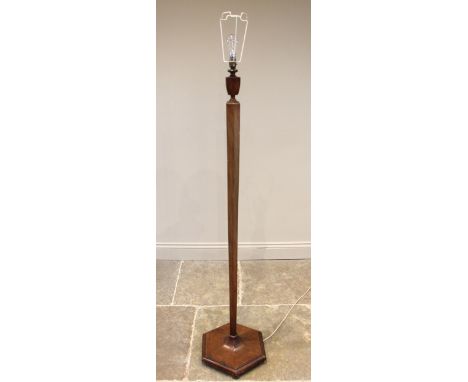 An Art Deco walnut standard lamp, circa 1930, the urn and hexagonal tapering column extending to a spreading plinth base upon